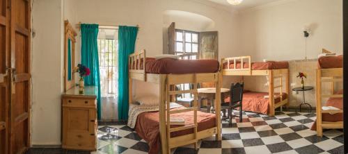a dorm room with bunk beds and a checkered floor at Casa Lupita Hostel in Guanajuato
