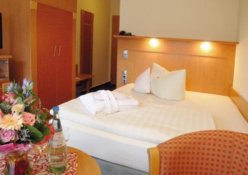 a hotel room with a bed and a table at Hotel Königshof in Garmisch-Partenkirchen