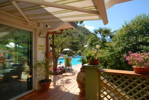 a porch with potted plants and a swimming pool at Delle Rose Camping & Glamping Village in Isolabona