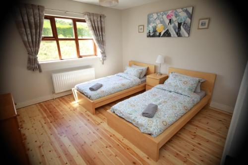 1 Schlafzimmer mit 2 Betten und einem Fenster in der Unterkunft Alices Loft & Cottages in Castleblayney