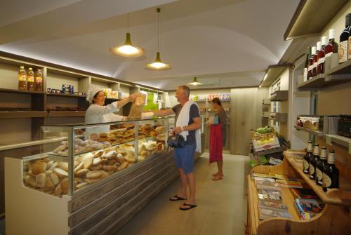 a man and a woman standing in a bakery at Delle Rose Camping & Glamping Village in Isolabona