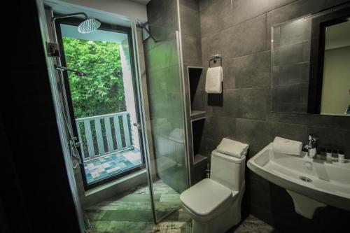 a bathroom with a shower and a toilet and a sink at Borjomi UnderWood in Borjomi