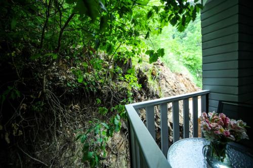 a porch with a vase of flowers and a table at Borjomi UnderWood in Borjomi