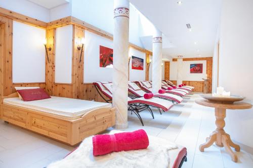 a room with a row of beds and a table at Hotel Riedl im Zillertal in Stumm