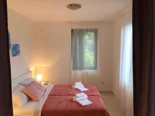 a bedroom with a bed with towels on it at APARTMANI PETRIJA in Prčanj