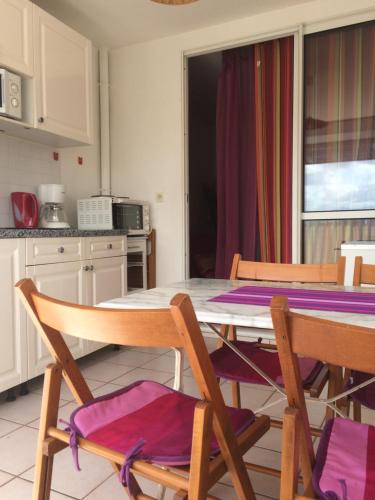 eine Küche mit einem Tisch mit 2 Stühlen, einem Tisch und einem Tisch in der Unterkunft T2 à deux pas de la plage, résidence Anse Plage in Les Trois-Îlets