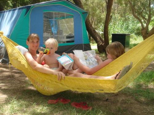 two women and a baby sitting in a hammock at Camping Mithimna in Kissamos
