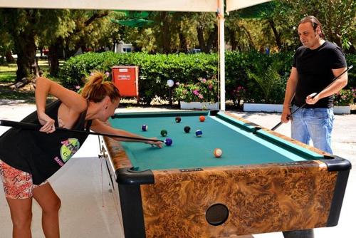 a man and a woman playing a game of pool at Camping Mithimna in Kissamos