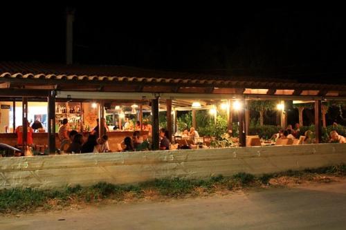a group of people sitting at a restaurant at night at Camping Mithimna in Kissamos