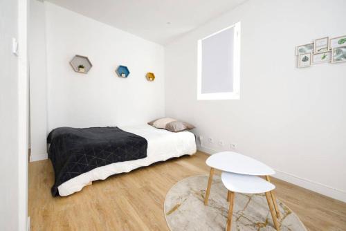 - une chambre blanche avec un lit et une chaise dans l'établissement Le Petit Martégal appartement spacieux en Centre ville et proche de la plage, à Martigues