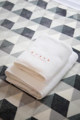 a white towel sitting on a checkered floor at Apartmani Mursa in Osijek