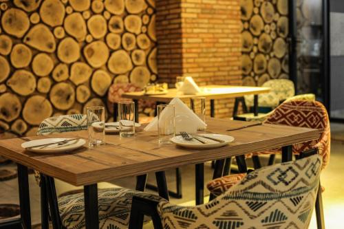 a wooden table with plates and glasses on it at Borjomi UnderWood in Borjomi