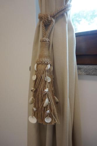 a curtain with seashells on the side of a window at Sperlonga By The Sea in Sperlonga