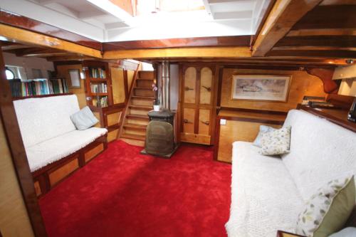 um quarto com duas camas e uma lareira num comboio em Historic Wooden Ship 'MFV119' em East Cowes