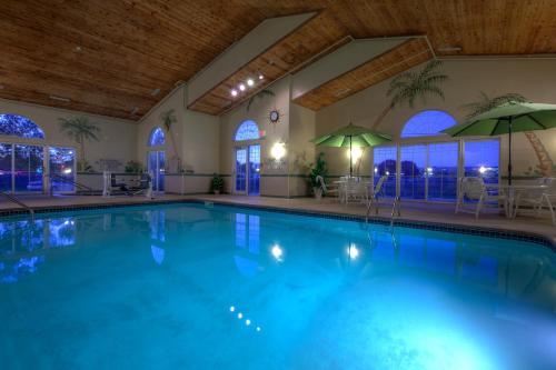 a large swimming pool with tables and umbrellas at Country Inn & Suites by Radisson, Waterloo, IA in Waterloo