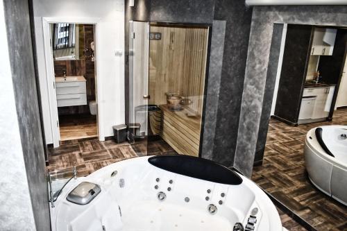 a bathroom with a bath tub and a sink at De Lux Apartment Maki in Banja Luka