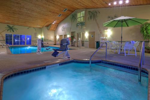 a indoor swimming pool with an umbrella and a swimming pool at Country Inn & Suites by Radisson, Waterloo, IA in Waterloo