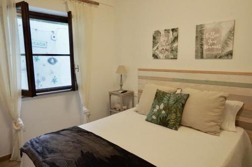 a bedroom with a white bed with a window at Sperlonga By The Sea in Sperlonga