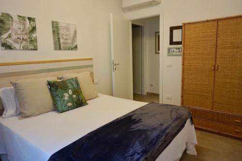 a bedroom with a large bed and a wooden cabinet at Sperlonga By The Sea in Sperlonga