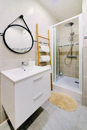 une salle de bain blanche avec un lavabo et un miroir dans l'établissement Le Petit Martégal appartement spacieux en Centre ville et proche de la plage, à Martigues