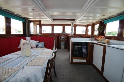 a train car with a table and a kitchen in it at Historic Wooden Ship 'MFV119' in East Cowes