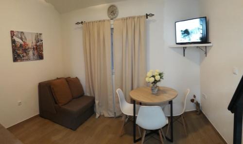 a small living room with a table and a chair at Kustudic Apartments in Tivat