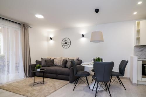a living room with a couch and a table and chairs at FK Apartments in Pakoštane