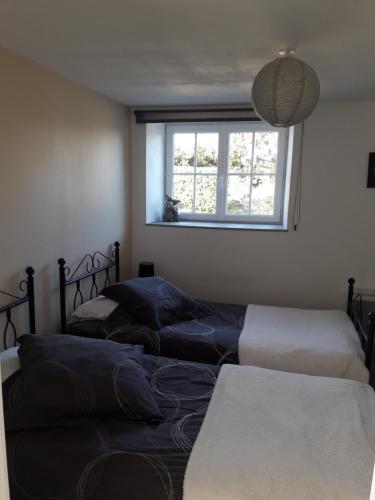 três camas num quarto com uma janela em Les Peupliers em Vesly