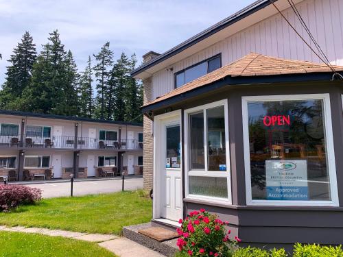 an open sign in a window in front of a building at City Centre Motel older building in Hope