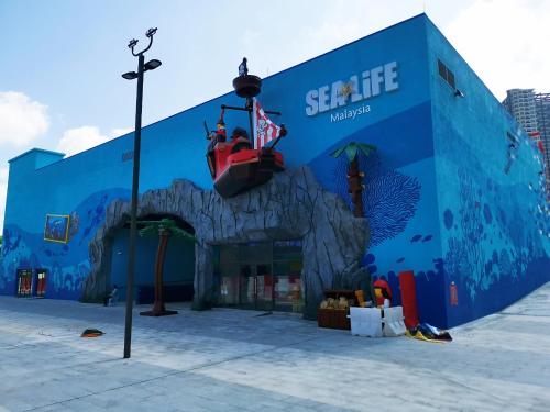 a blue building with people riding on a roller coaster at Grand Medini Suites by RR JBcity in Nusajaya