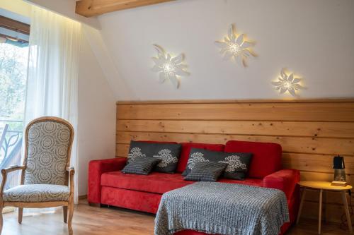 a living room with a red couch and a chair at Willa Ryś in Zakopane
