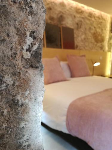 a bedroom with a bed and a stone wall at Old Town SXVI - Adults Only in Telde