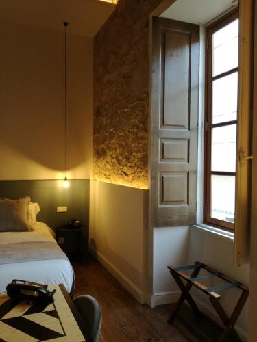 a bedroom with a bed and a window and a table at Old Town SXVI - Adults Only in Telde