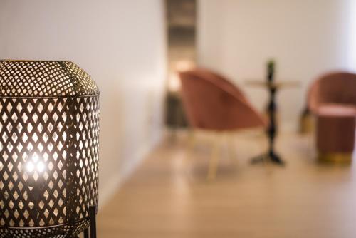 a trash can in a room with a table and chairs at Casa das Arcadas in Ponta Delgada
