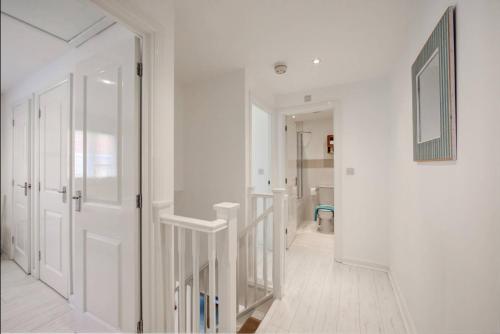 un corridoio con pareti bianche e porta bianca e un bagno di Saltwater Cottage a Camber