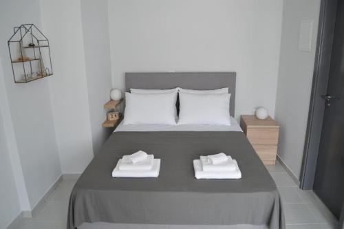 a bedroom with a bed with two white towels on it at MV House Agia Marina in Agia Marina Nea Kydonias
