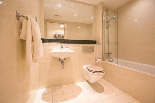 a bathroom with a toilet and a sink and a shower at Grand Canal Square Apartments in Dublin