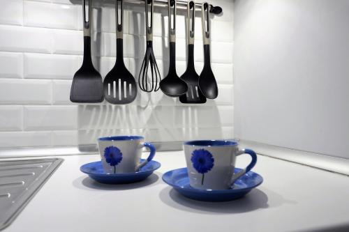 dos tazas azules y tenedores y cucharas en un mostrador de cocina en Mesa del Mar Sunset Dream vacational rental home, en Puerto de la Madera
