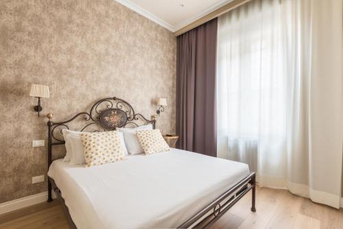una camera da letto con un grande letto bianco e una finestra di Elegant and cozy flat heart of Florence a Firenze