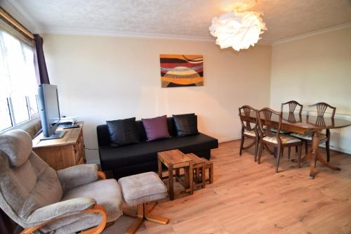 ein Wohnzimmer mit einem Sofa und einem Esstisch in der Unterkunft The Chinatown Home - Private Garden, NETFLIX, BBQ & Bar in Birmingham