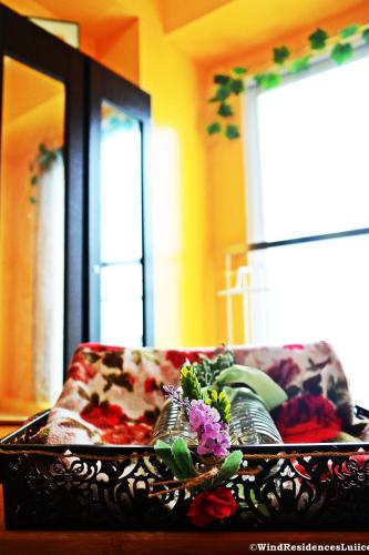 a tray with flowers on top of a couch at Wind Residences For Rent - Luiice in Tagaytay