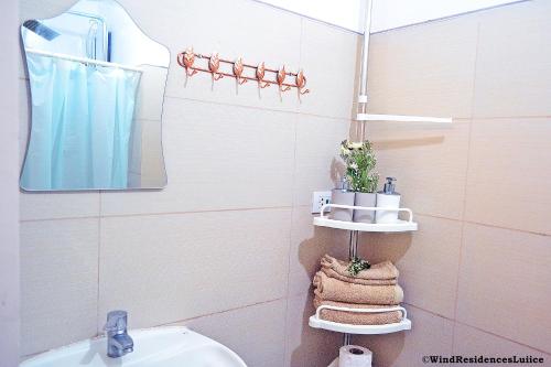 a bathroom with a sink and a toilet and a mirror at Wind Residences For Rent - Luiice in Tagaytay