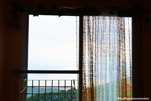 a window with a view of a building at Wind Residences For Rent - Luiice in Tagaytay