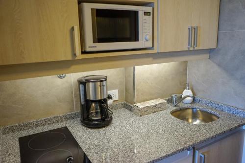un bancone da cucina con un microonde e un lavandino di Patagonia Suite a San Carlos de Bariloche