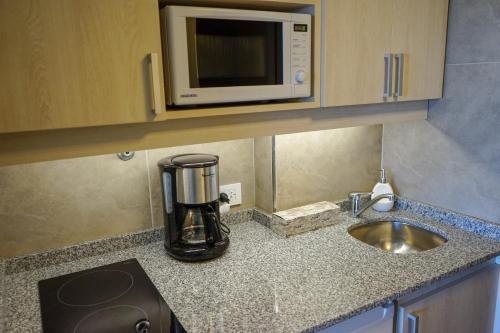 a kitchen counter with a microwave and a sink at Patagonia Suite in San Carlos de Bariloche