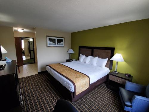 a hotel room with a large bed and a chair at Best Western Adena Inn in Chillicothe