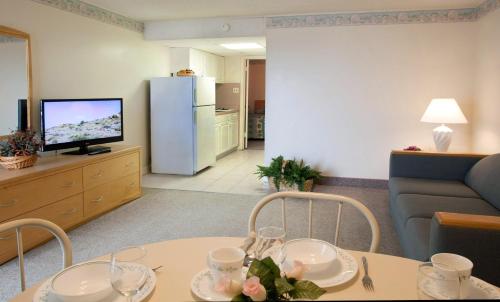 a living room with a table and a couch and a television at Lotus Inn in Wildwood Crest