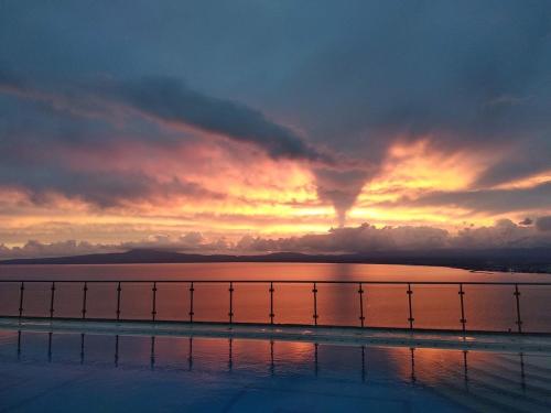 a sunset over a body of water with a bridge at Belvedere Hotel in Kalamata