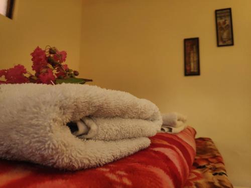 a pile of towels sitting on top of a bed at Nature Care Village- Rajaji National Park in Rishīkesh