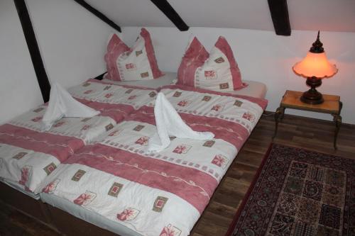 a bedroom with two beds with red and white sheets at Penzion St. Florian Příbor in Příbor